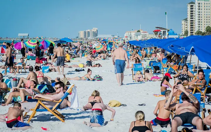 Crowded white-sand Clearwater Beach with beach umbrellas and hotels behind