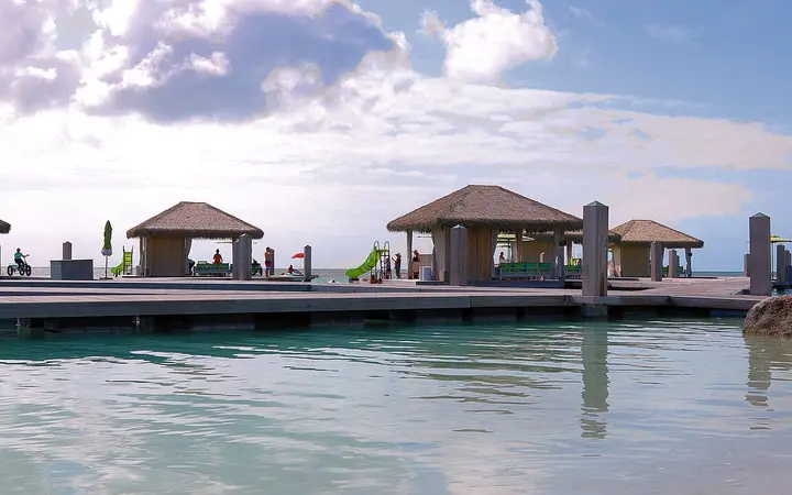 Thatched overwater cabanas on a boardwalk at Coco Beach Club, CocoCay