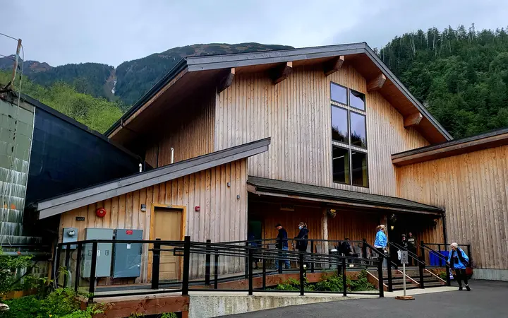 Wooden visitor building of Fortress of the Bear with forested mountains behind