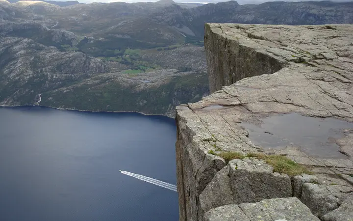 A boat on Lysefjorden below the Preikestolen cliff