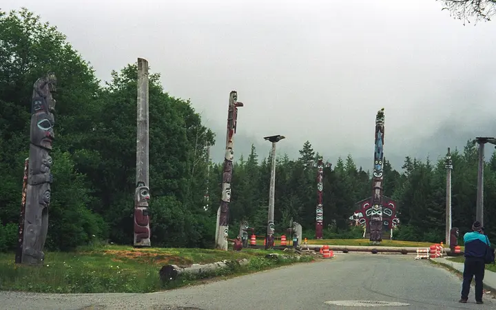 Row of totem poles lining the road through Saxman Totem Park