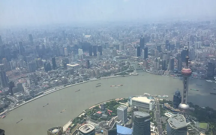 View down from the Shanghai Tower observation deck over the Oriental Pearl Tower, the Huangpu River and the Bund