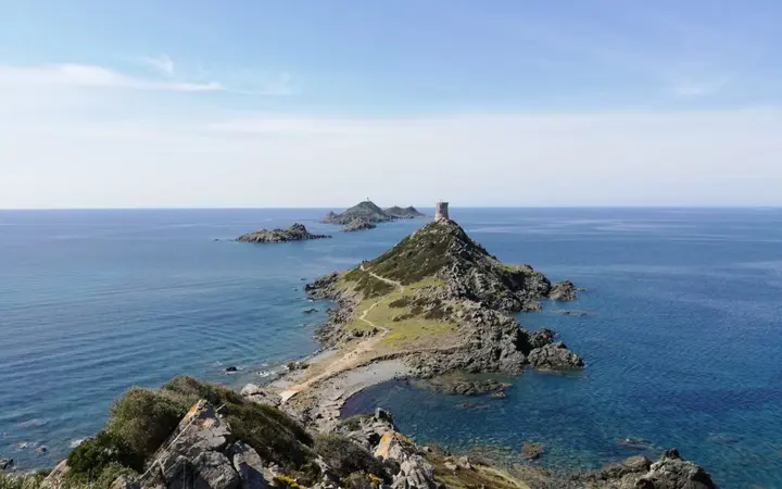 View from La Parata over the Genoese tower on its rocky headland and the Sanguinaires Islands in a blue sea on a sunny day