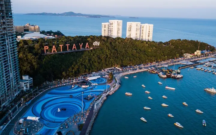 Aerial view of Pattaya Bay with boats, the waterfront and the Pattaya hillside sign.