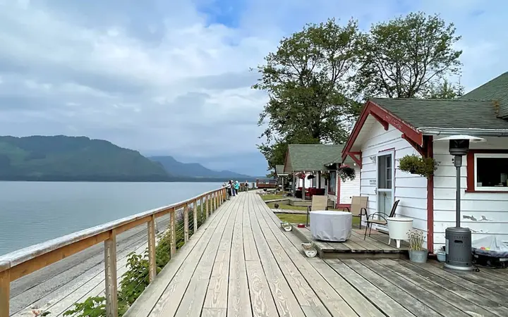Wooden boardwalk beside historic buildings and the water at Icy Strait Point, Alaska