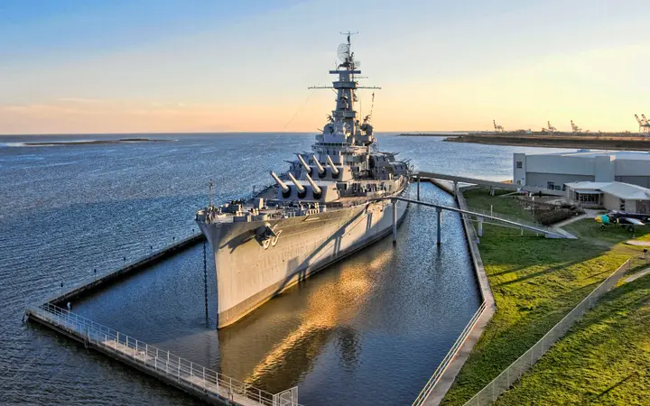 The battleship USS ALABAMA moored at Battleship Memorial Park on Mobile Bay at golden hour